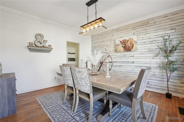 dining area with ornamental molding, wood finished floors, and baseboards