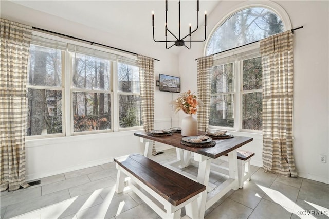 dining area with a chandelier, baseboards, tile patterned floors, and a healthy amount of sunlight