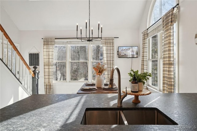 dining room featuring a chandelier, plenty of natural light, and stairs