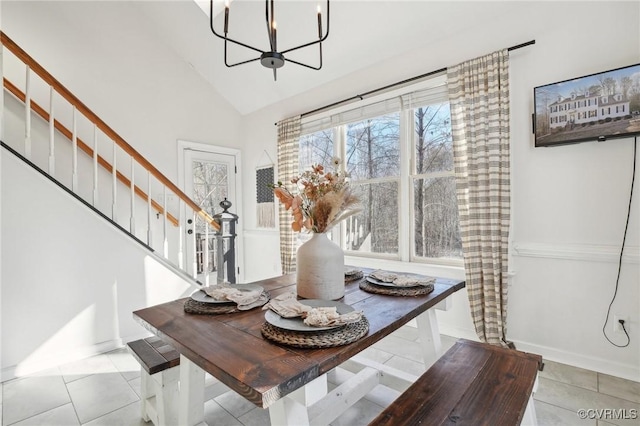 dining area with lofted ceiling, baseboards, stairway, tile patterned floors, and an inviting chandelier