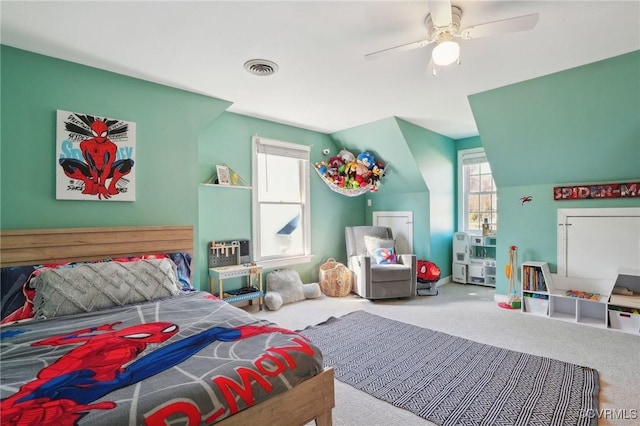 carpeted bedroom with ceiling fan, multiple windows, and visible vents