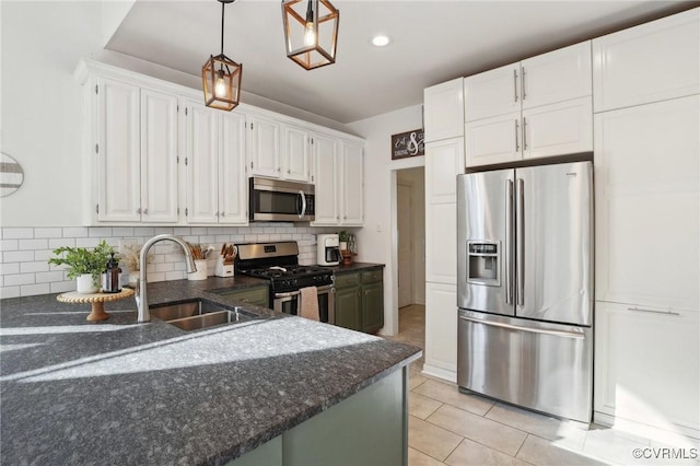 kitchen featuring white cabinets, dark stone counters, stainless steel appliances, and decorative backsplash