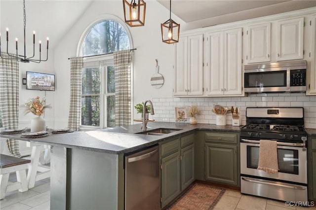 kitchen featuring light tile patterned floors, a sink, white cabinetry, appliances with stainless steel finishes, and backsplash