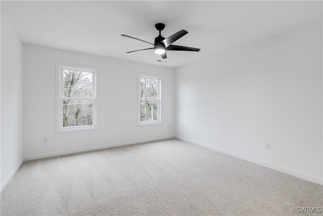 spare room with a ceiling fan, carpet, and baseboards