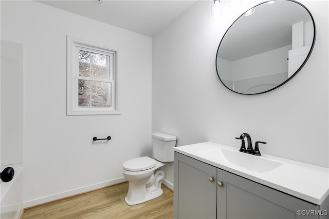 full bathroom with baseboards, vanity, toilet, and wood finished floors