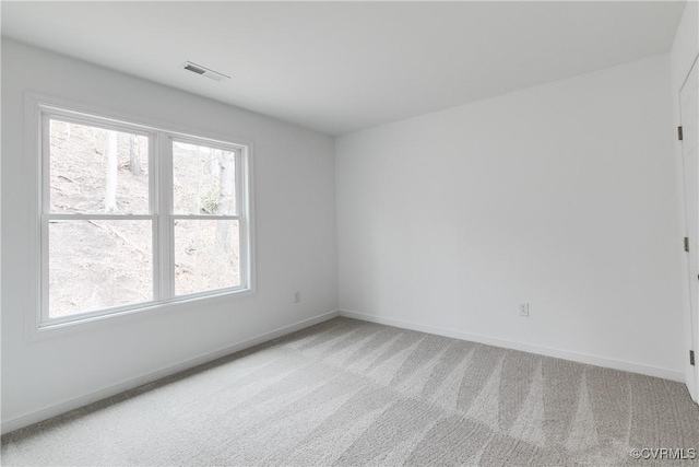 empty room with light carpet, baseboards, and visible vents