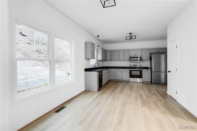 kitchen with dark countertops, visible vents, appliances with stainless steel finishes, and gray cabinetry