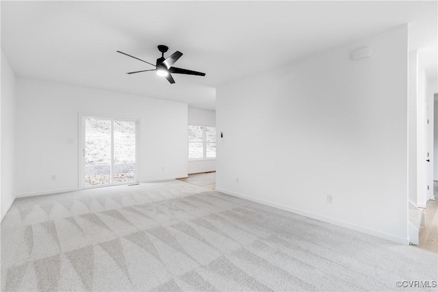 empty room with light carpet, ceiling fan, and baseboards