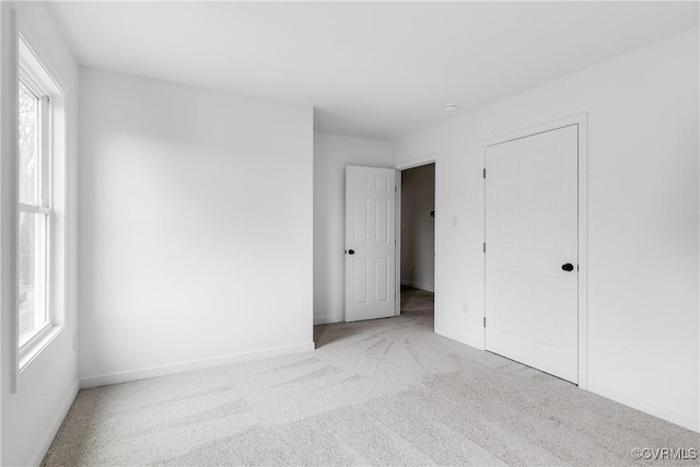 unfurnished bedroom featuring carpet flooring and baseboards