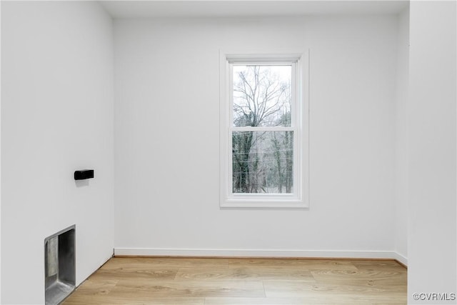 laundry room featuring light wood-style flooring and baseboards