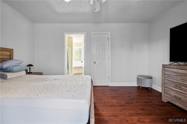 bedroom featuring a textured ceiling, dark wood finished floors, connected bathroom, baseboards, and ceiling fan