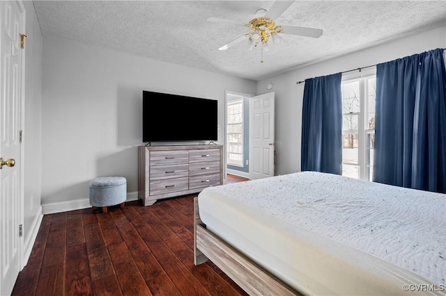 bedroom with baseboards, a textured ceiling, dark wood finished floors, and a ceiling fan