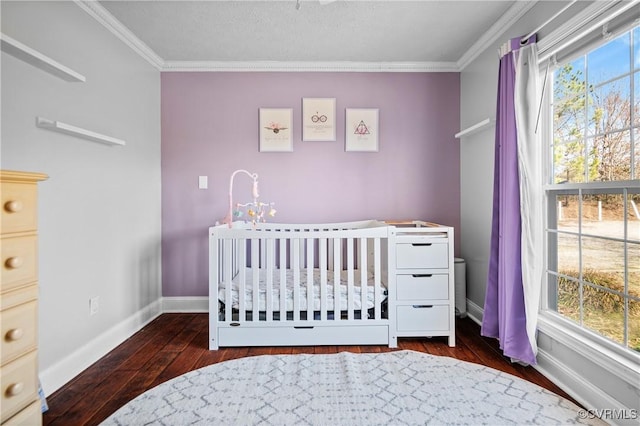 bedroom featuring hardwood / wood-style floors, crown molding, a nursery area, and baseboards