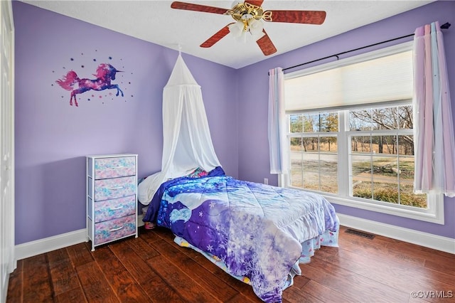 bedroom featuring hardwood / wood-style floors, baseboards, visible vents, and a ceiling fan