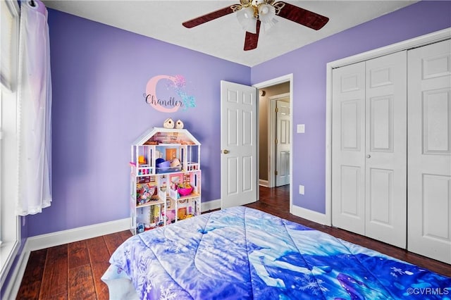 bedroom featuring a closet, baseboards, wood finished floors, and a ceiling fan