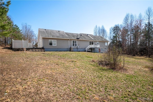 back of house with a lawn and fence