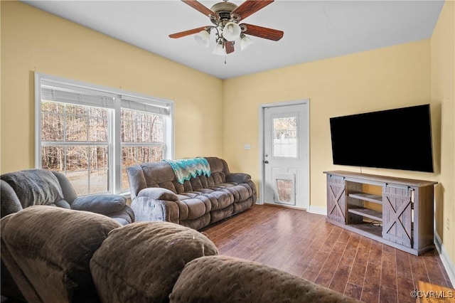 living room featuring a ceiling fan, wood finished floors, and baseboards