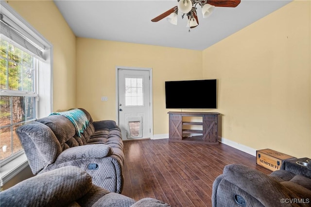 living area with a healthy amount of sunlight, baseboards, ceiling fan, and wood finished floors