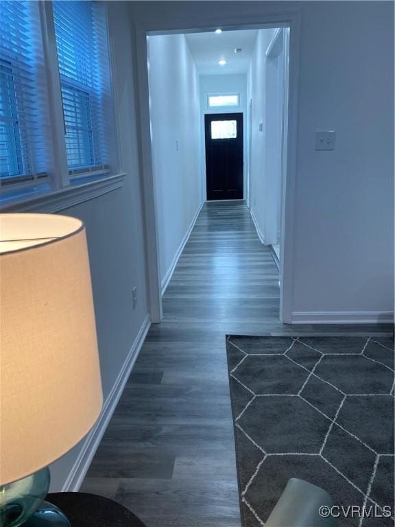 hallway featuring baseboards and wood finished floors