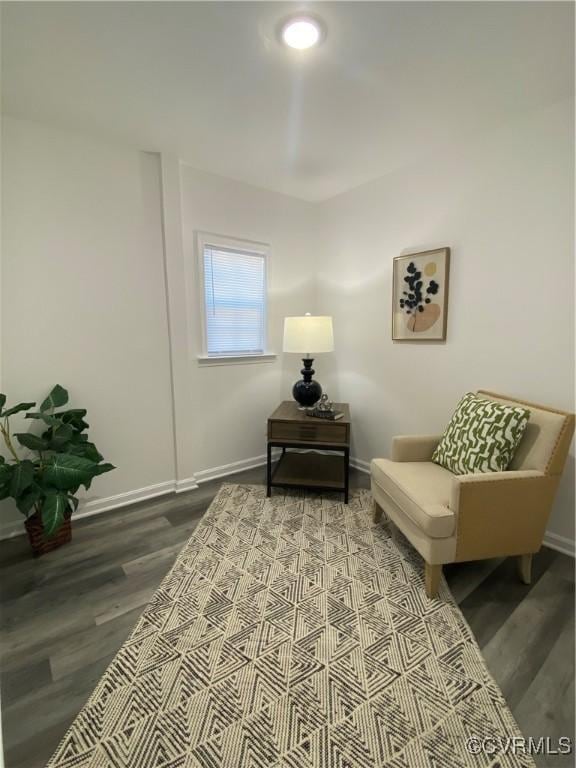 living area featuring baseboards and wood finished floors