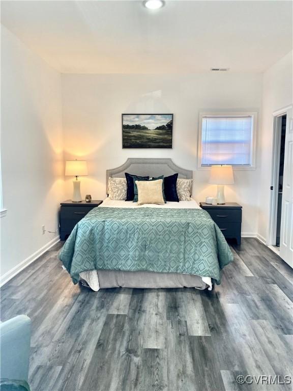 bedroom featuring dark wood-type flooring, visible vents, and baseboards