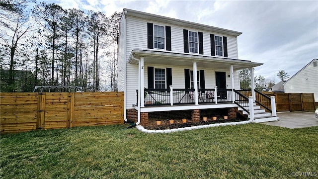 view of front facade with a gate, covered porch, a front lawn, and fence