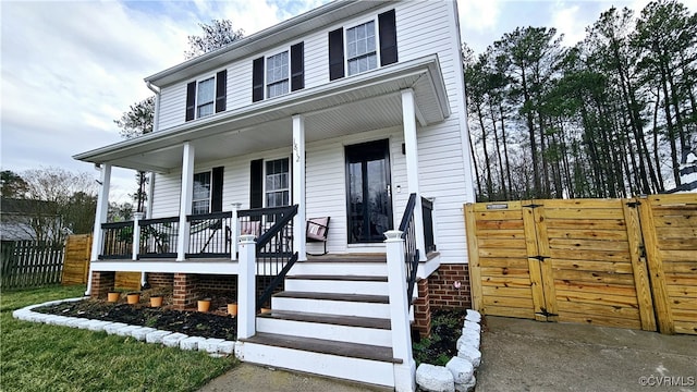 view of front facade featuring fence, a porch, and a gate