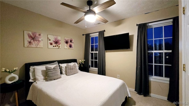 bedroom with visible vents, light colored carpet, a ceiling fan, and baseboards