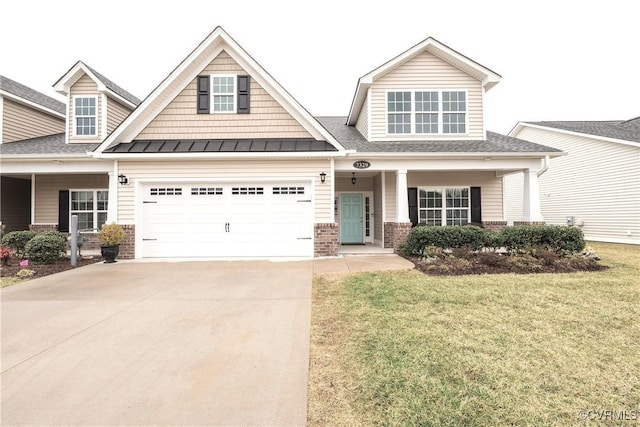 craftsman-style home with an attached garage, brick siding, concrete driveway, a front lawn, and a standing seam roof