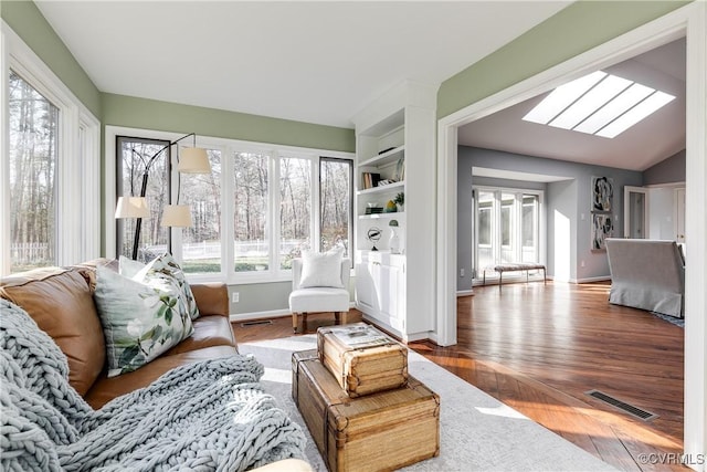 sunroom featuring vaulted ceiling with skylight and visible vents