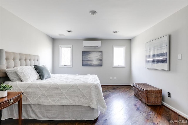 bedroom with dark wood-style flooring, a wall mounted air conditioner, visible vents, and baseboards