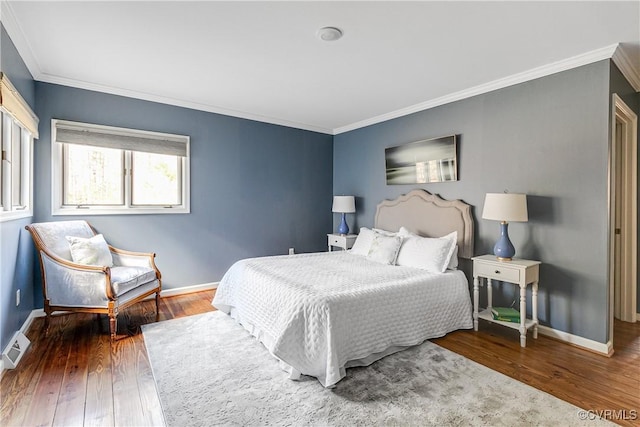 bedroom with visible vents, ornamental molding, hardwood / wood-style flooring, and baseboards