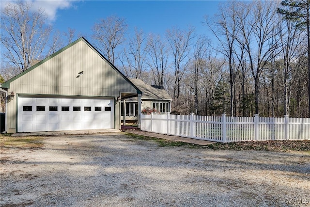 view of property exterior featuring driveway and a fenced front yard