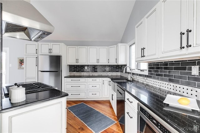 kitchen featuring stainless steel fridge, dishwashing machine, range hood, light wood-type flooring, and a sink