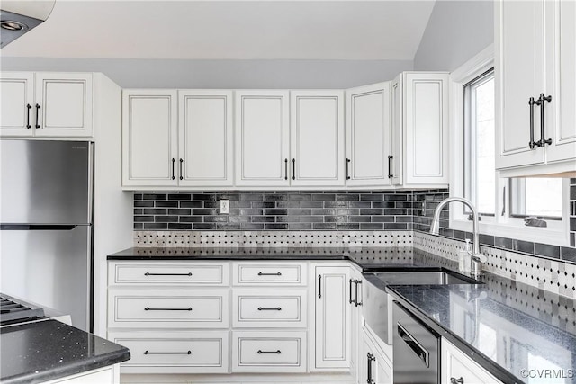 kitchen with white cabinets, freestanding refrigerator, and decorative backsplash