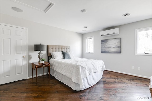 bedroom with multiple windows, visible vents, dark wood-style flooring, and a wall mounted AC