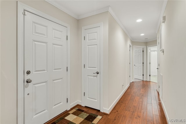 corridor with hardwood / wood-style flooring, baseboards, crown molding, and recessed lighting