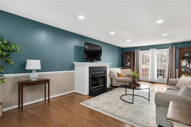 living room with a fireplace with flush hearth, recessed lighting, wood finished floors, and baseboards