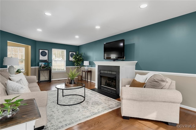 living area with a fireplace with flush hearth, wood finished floors, and recessed lighting