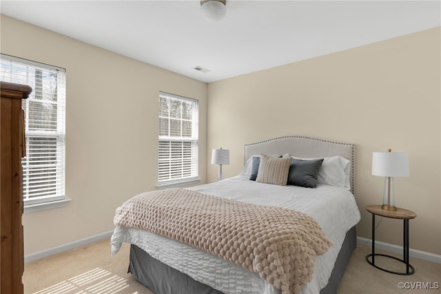 bedroom with light carpet, visible vents, and baseboards