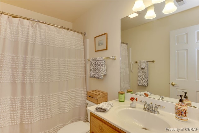 bathroom featuring toilet, visible vents, and vanity