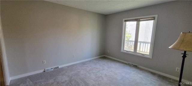 carpeted empty room featuring visible vents and baseboards