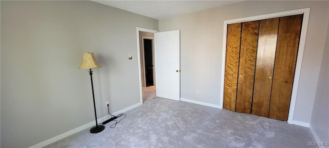 unfurnished bedroom with a closet, carpet flooring, and baseboards