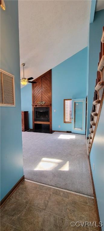 unfurnished living room featuring visible vents, a ceiling fan, carpet flooring, baseboards, and stairs