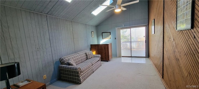 living area featuring ceiling fan, carpet floors, high vaulted ceiling, and wooden walls