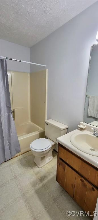 full bath with toilet, vanity, tile patterned floors, shower / bath combination with curtain, and a textured ceiling