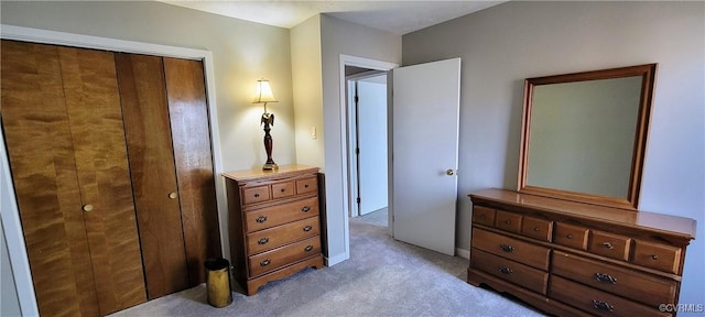 bedroom with light carpet and a closet