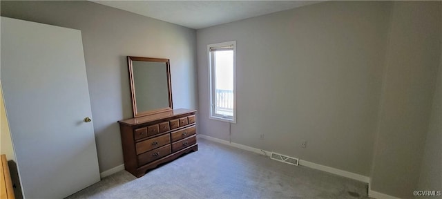 bedroom featuring visible vents, light carpet, and baseboards