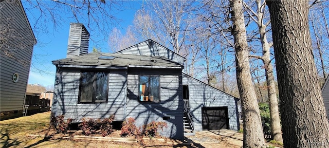 exterior space with a garage and a chimney