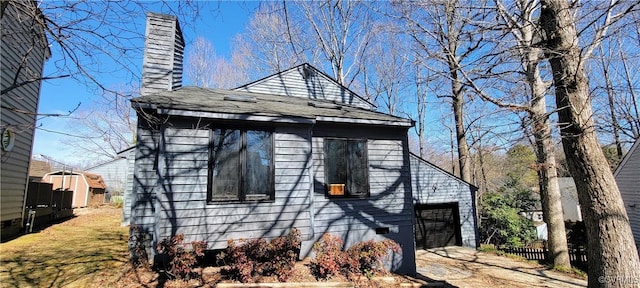 view of side of home with crawl space, dirt driveway, and a chimney